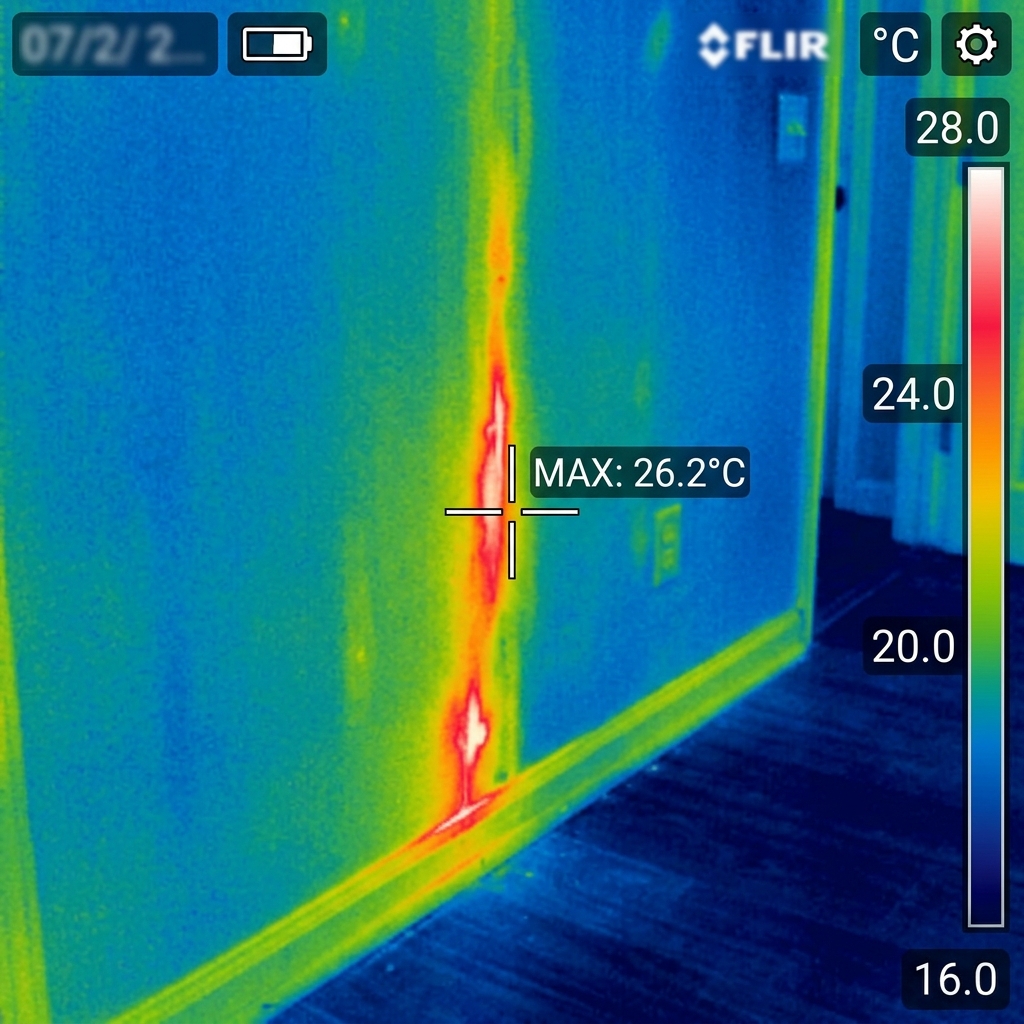 Thermal imaging camera view highlighting hidden termite activity behind a wall